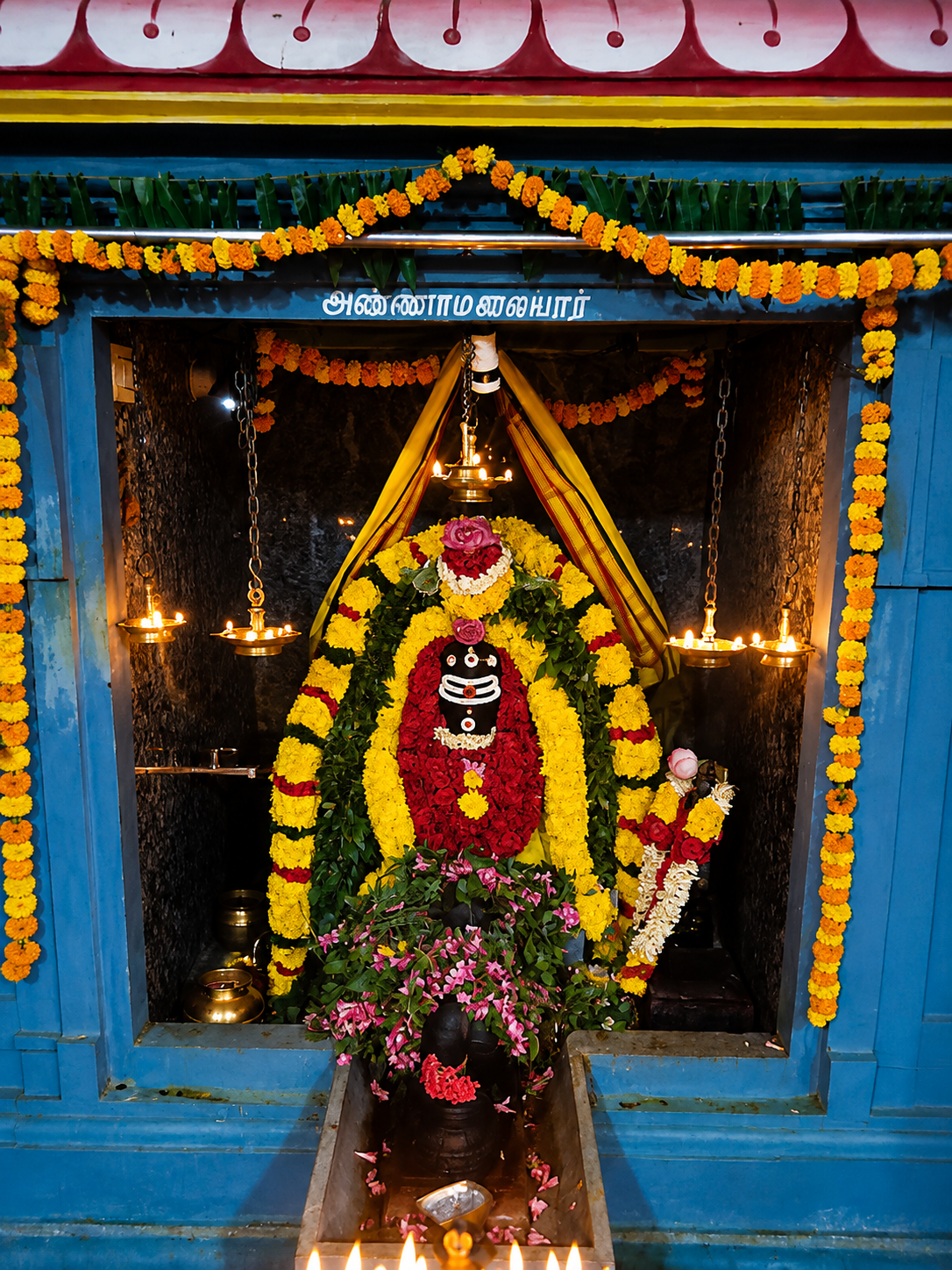 மலர் மாலைகளால் அலங்கரிக்கப்பட்ட அம்மன் திருவுருவம்